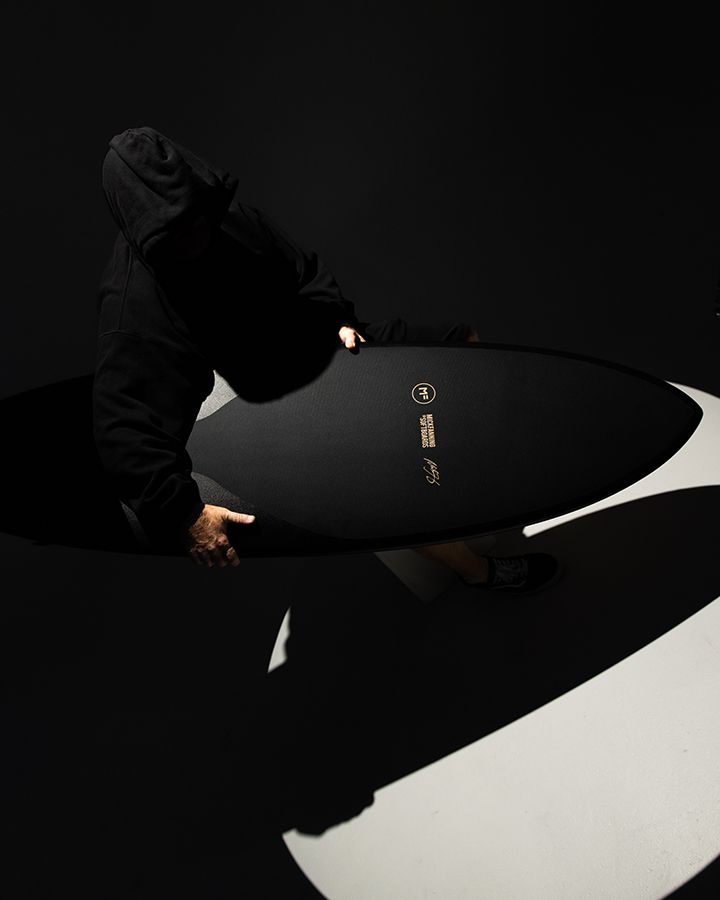 Black Mick Fanning Softboard carried through studio light, seen from above